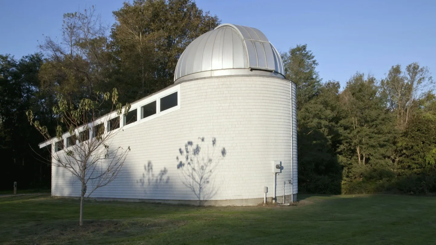 AI-generated atmosphere: the white shingled observatory on its lawn, animated from a 2011 public-domain photograph.