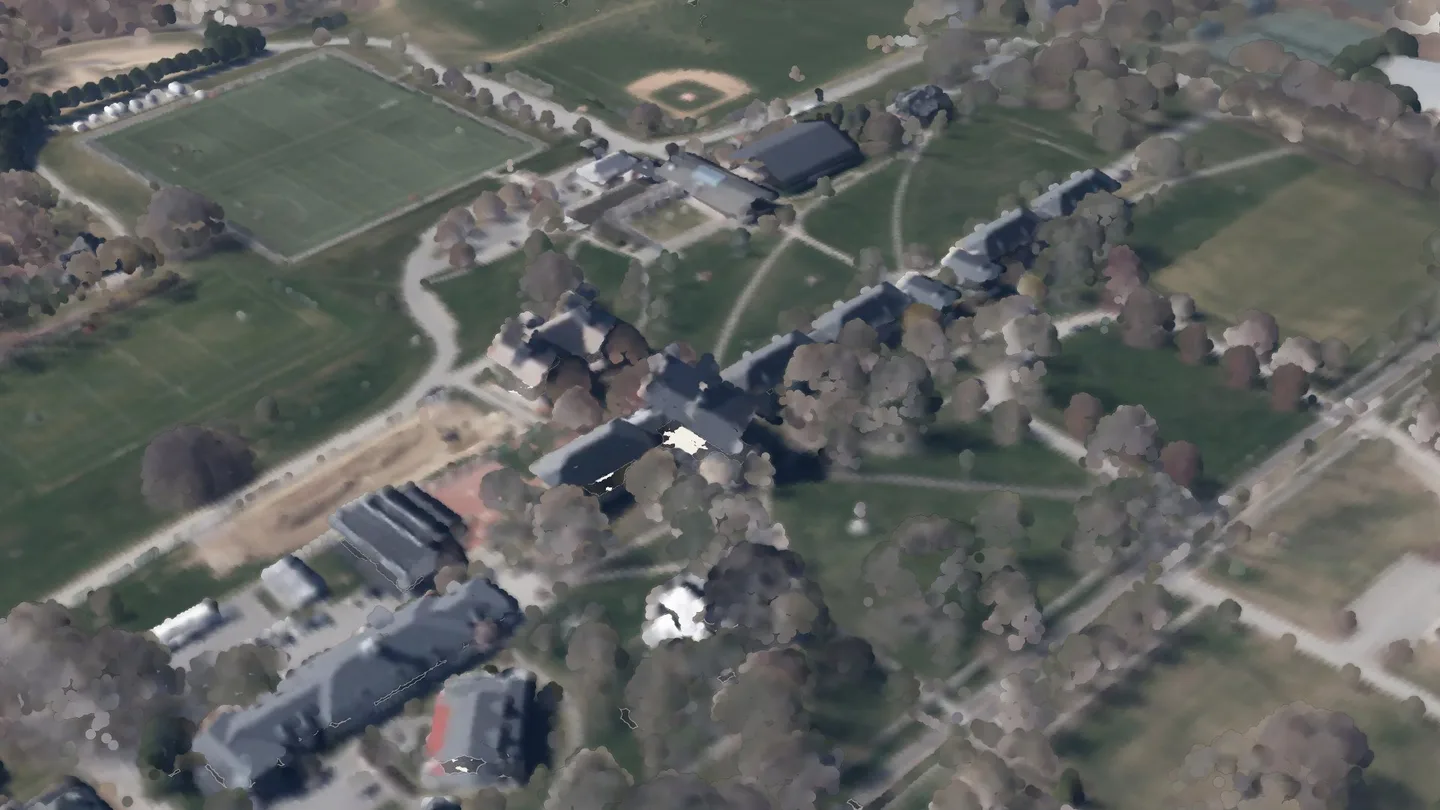 School House among its neighbours, seen from the air to the south-east: a render of the real 2023 LiDAR survey, coloured from the spring 2023 aerial photograph. A crimson ring marks its roof.
